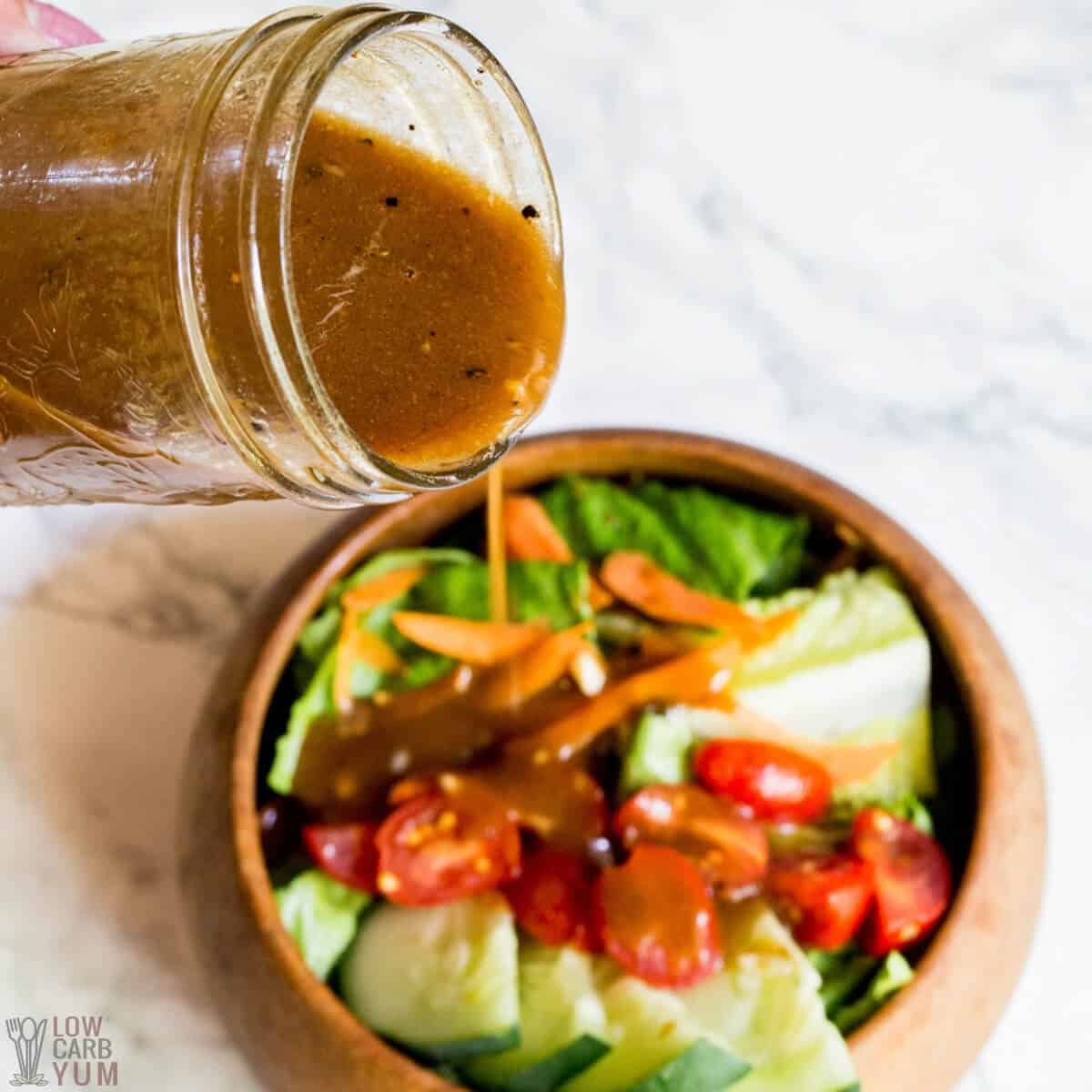 pouring balsamic vinaigrette dressing onto salad