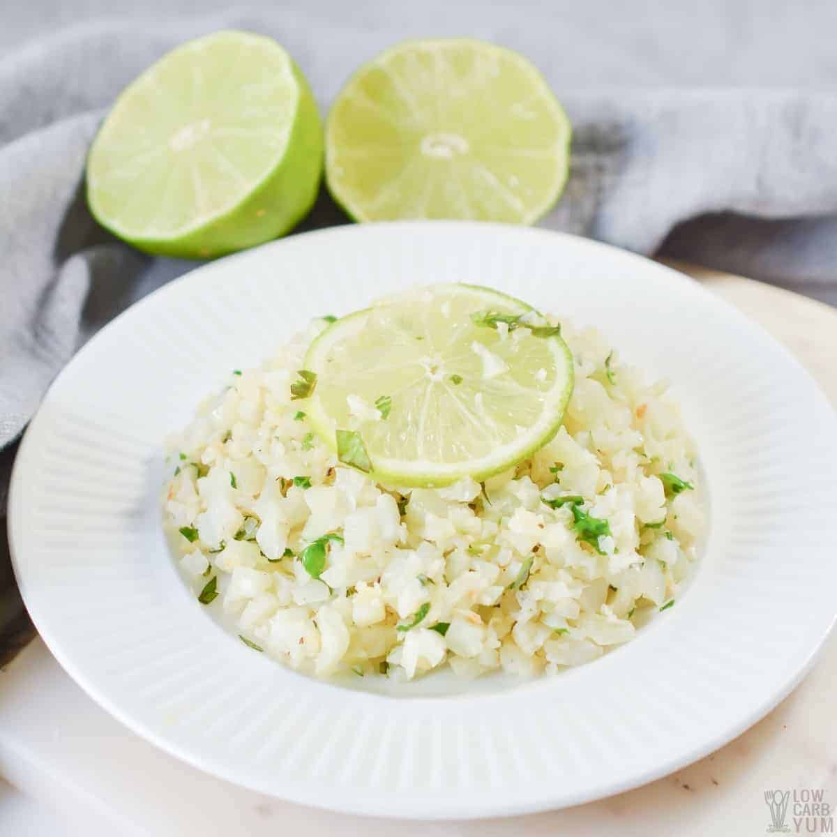 cilantro lime cauliflower rice on white plate with lime slice