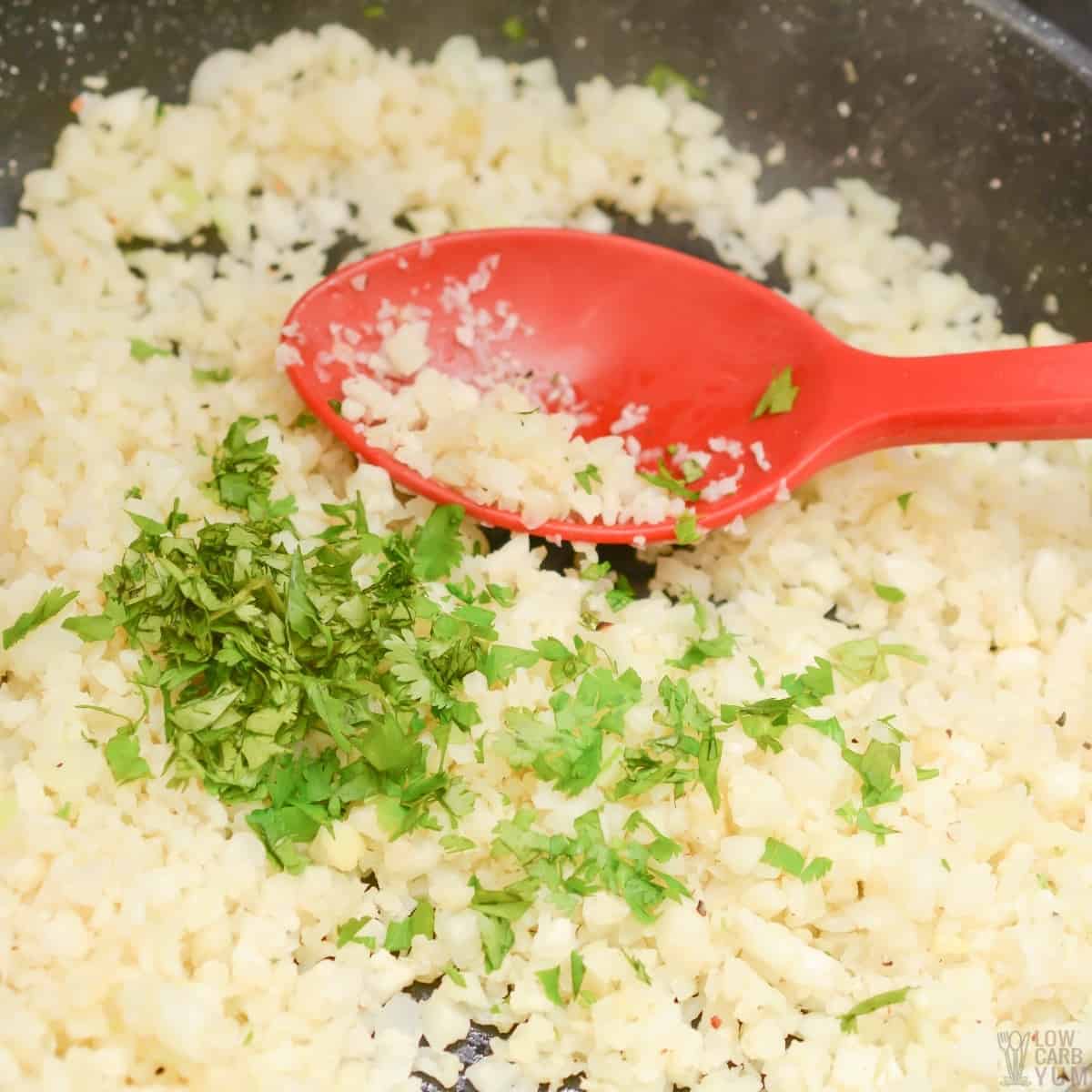 cilantro added to cauliflower rice in pan