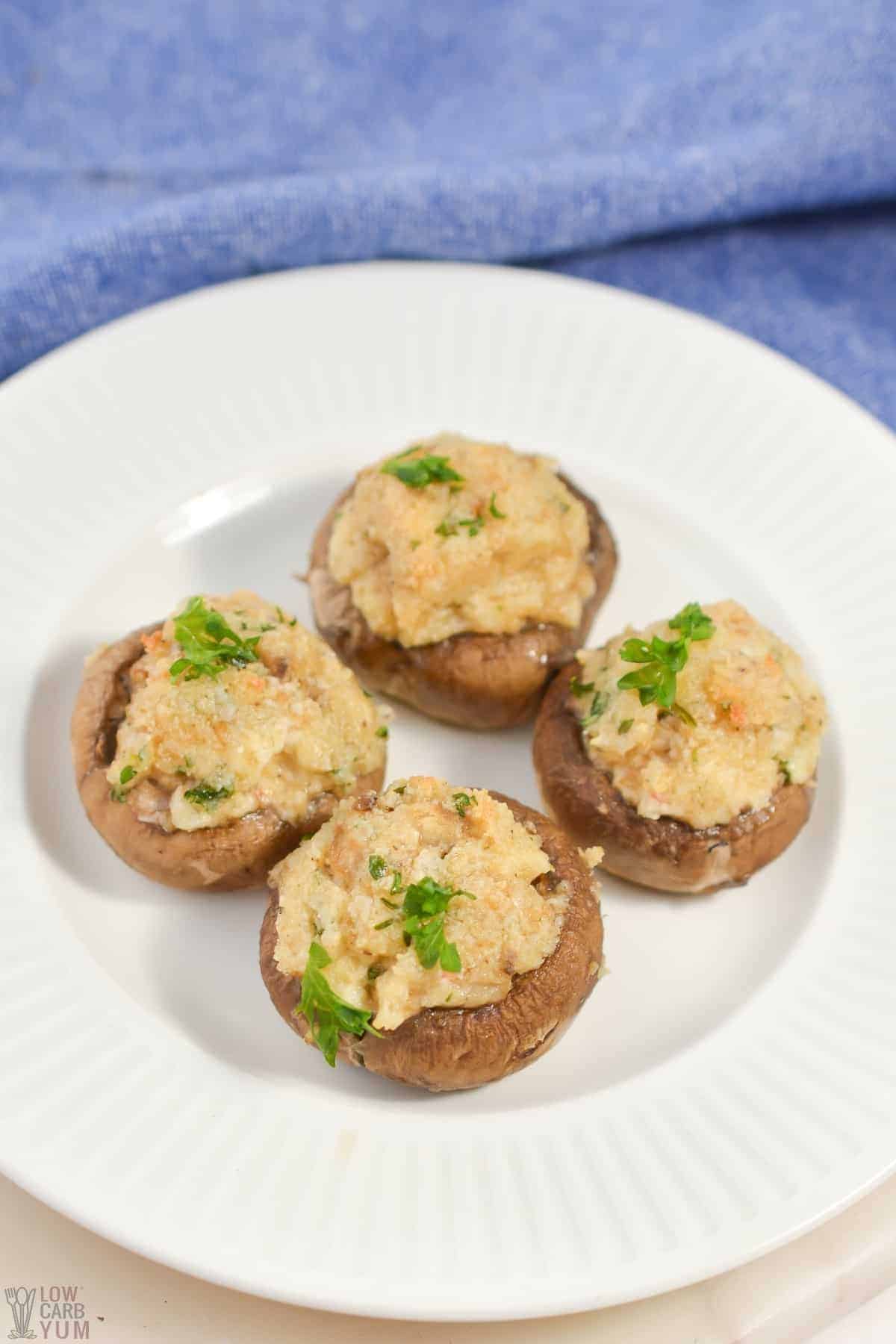 keto stuffed mushrooms on white plate with blue linen