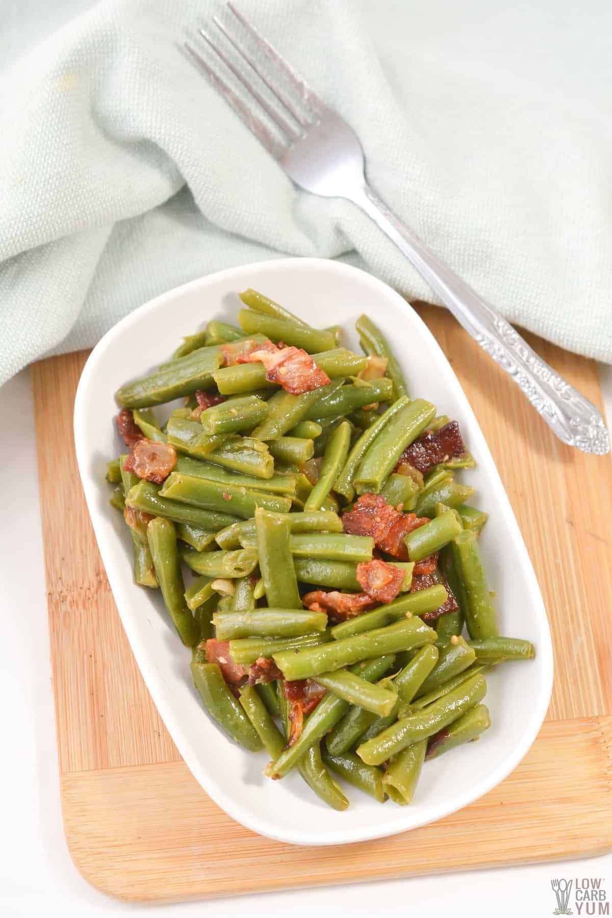 southern style keto green beans are served in a white baking dish