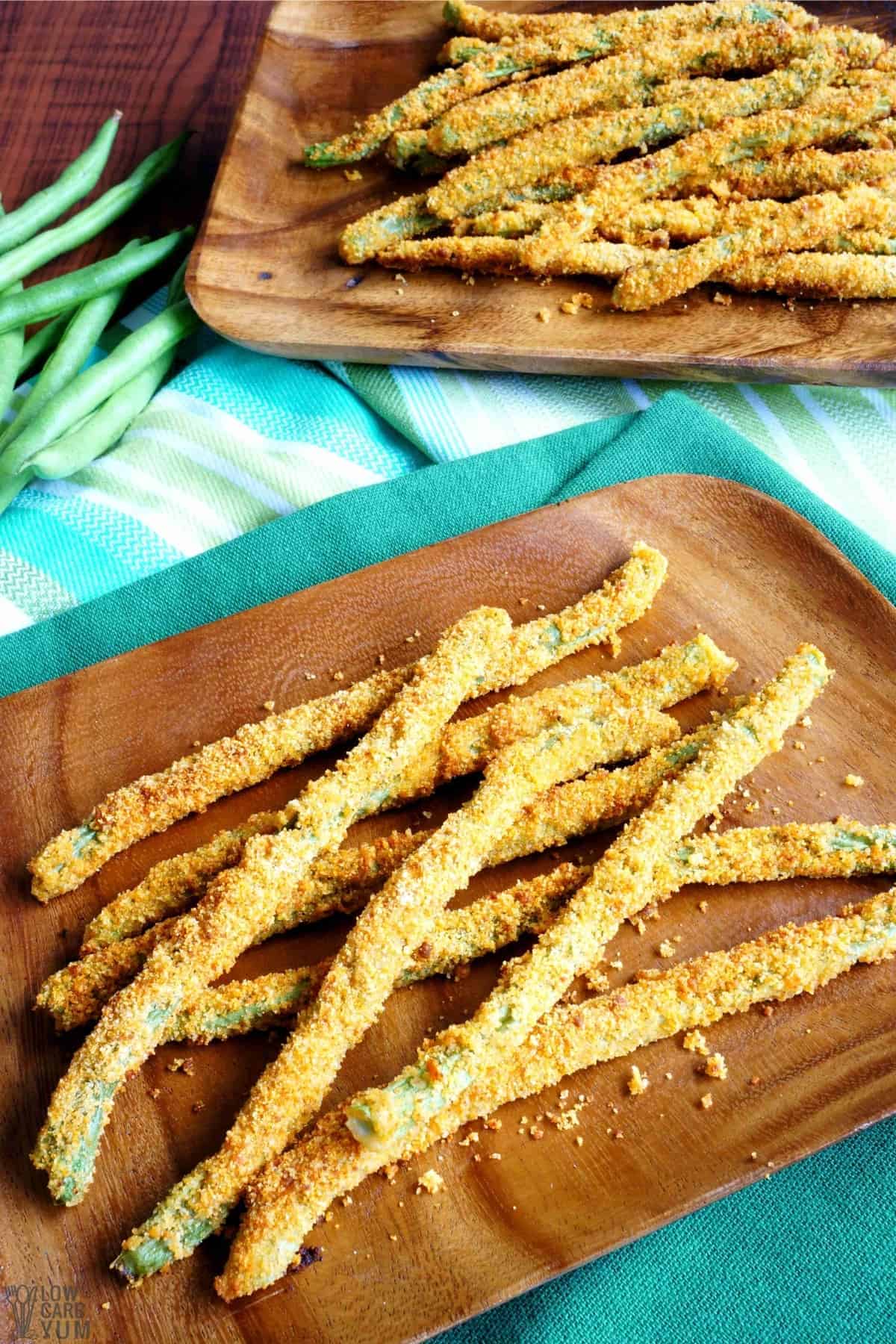keto green beans fries are piled on wood boards