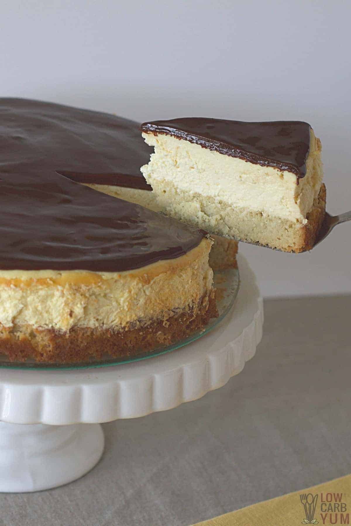 tall image of slicing the boston cream pie cheesecake on cake plate