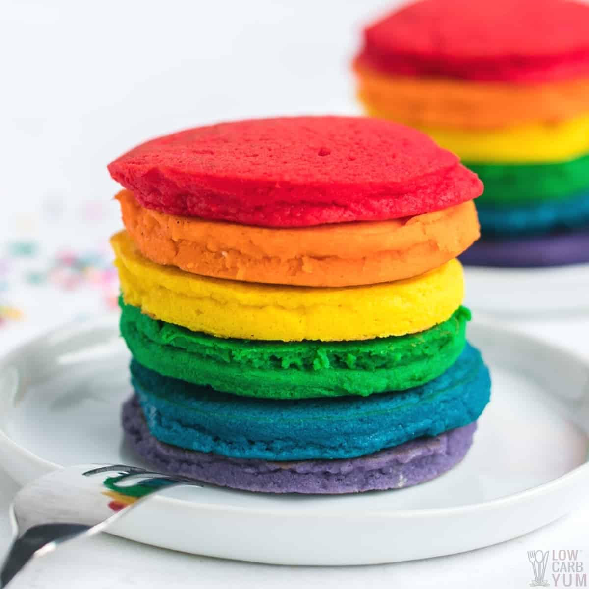 stacks of rainbow pancakes on white plates