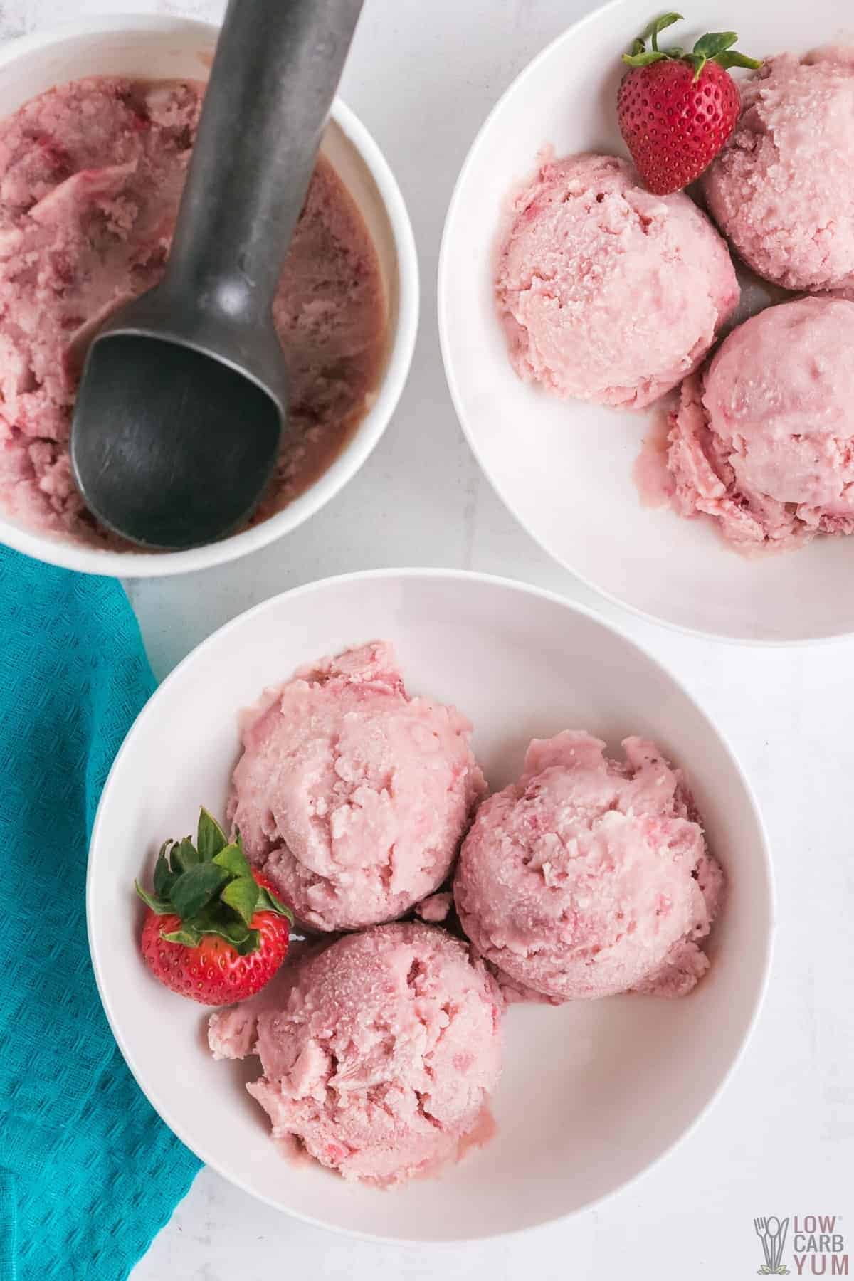 scoops of strawberry ice cream in white bowls