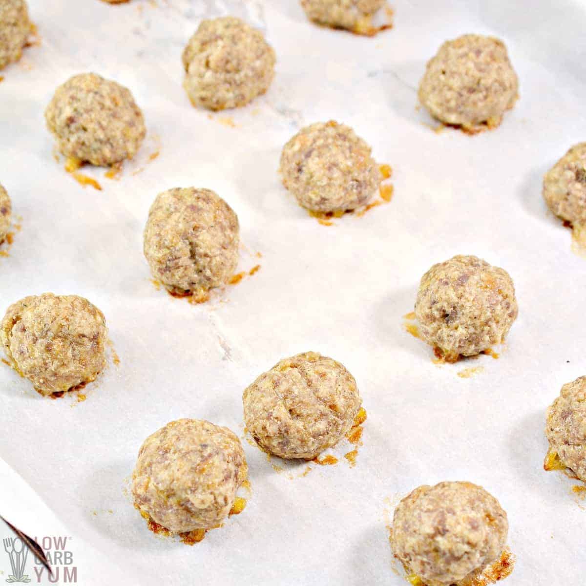 cooked sausage balls on lined baking sheet