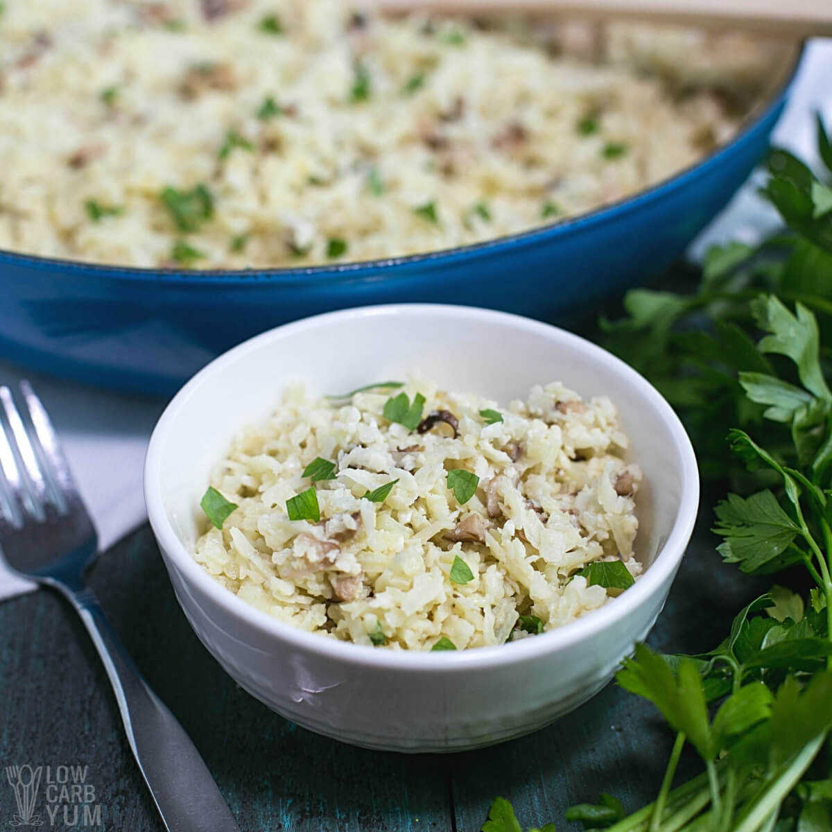 cauliflower mushroom risotto in bowl with pan in background