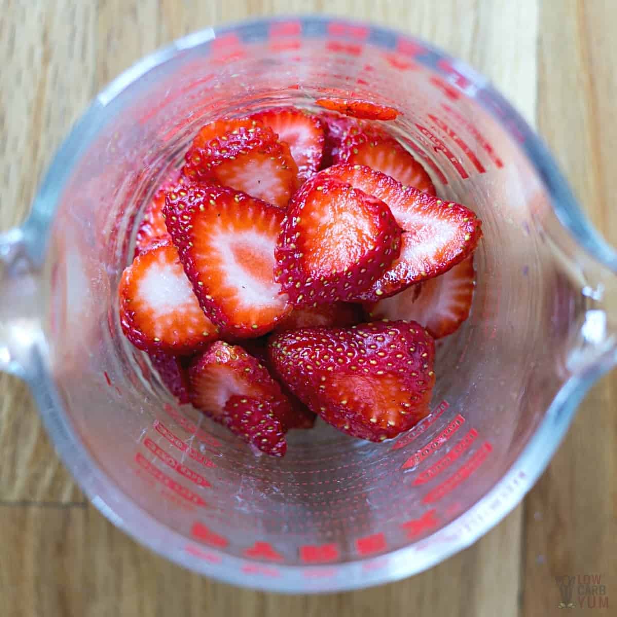 glass measuring cup with sliced strawberries