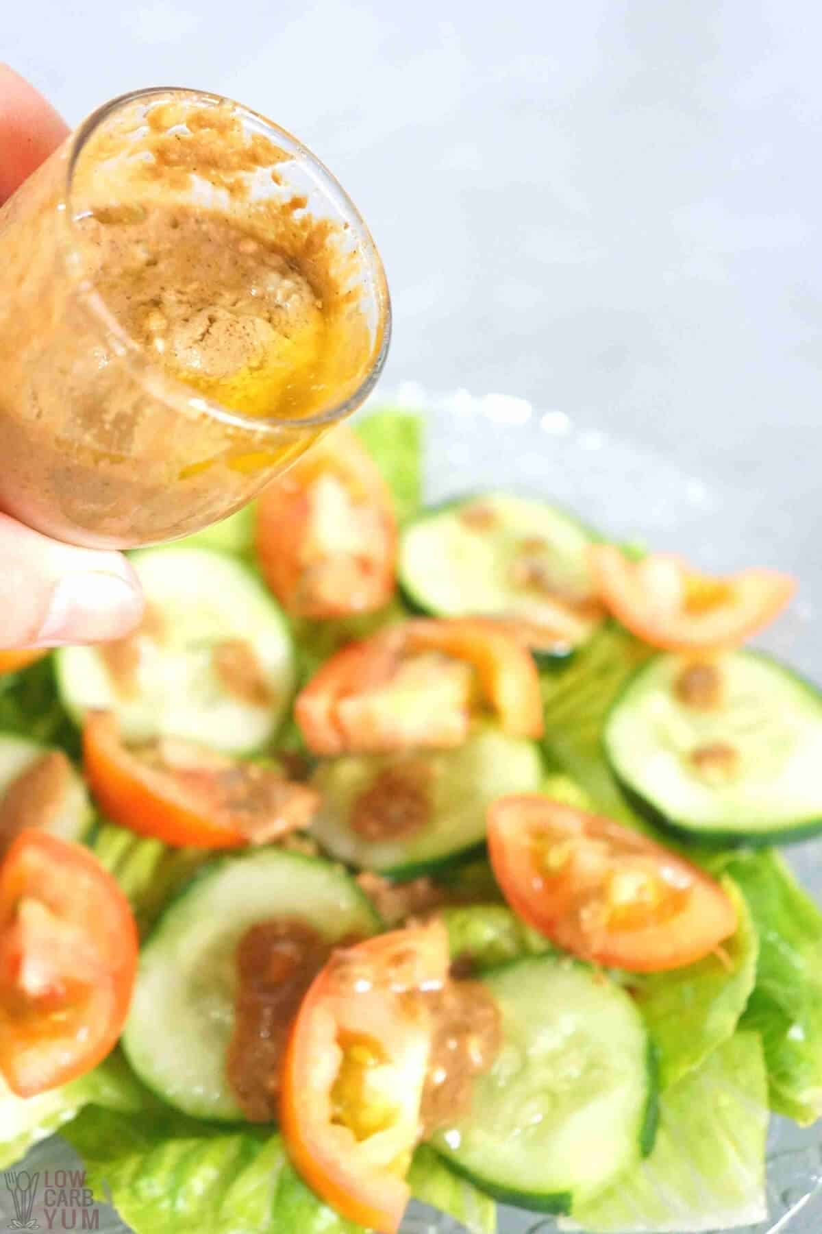 pouring dressing over salad