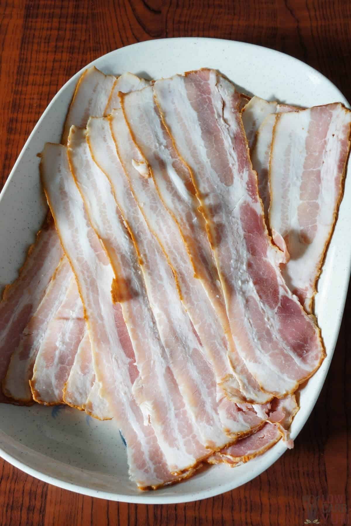 raw bacon strips on platter