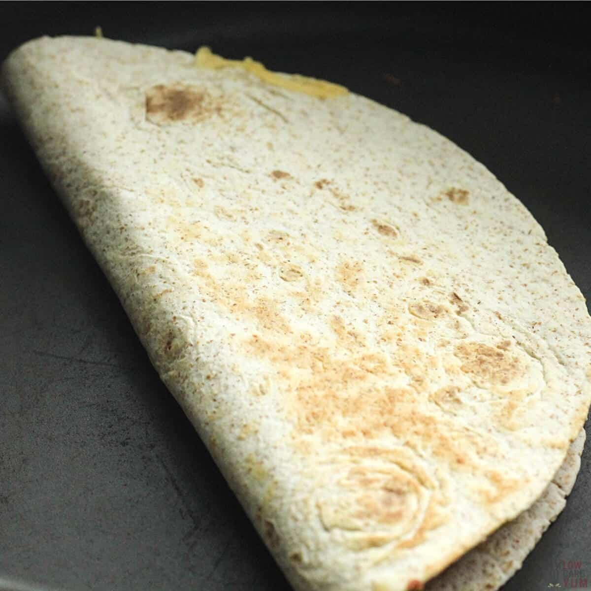 folded cheese quesadilla in pan