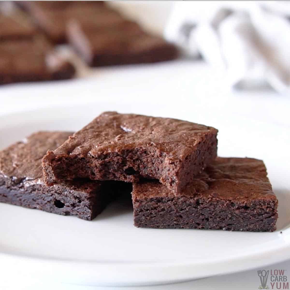 keto brownie stack on white plate with one bitten.