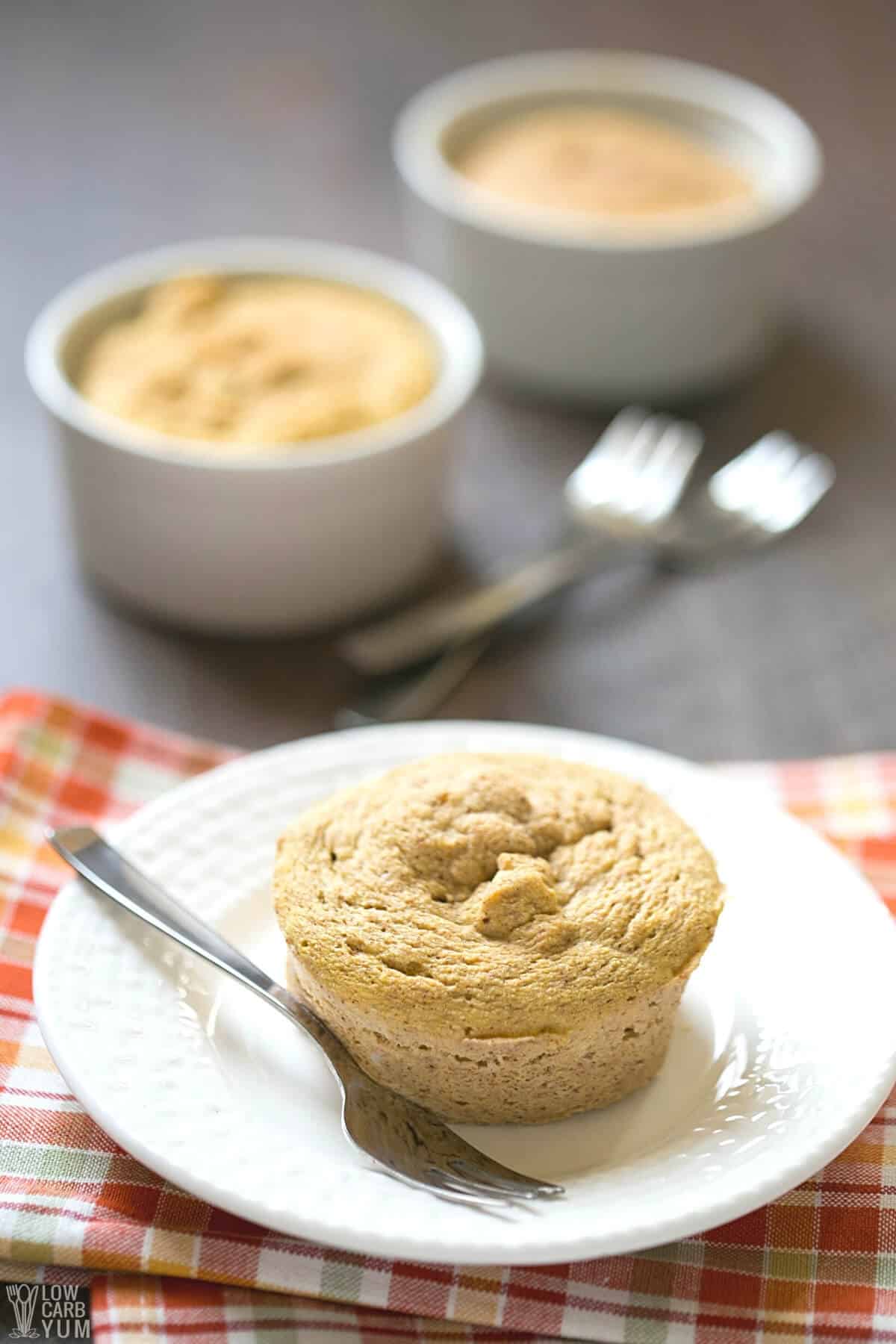 serving keto pumpkin mug cake on plate with fork