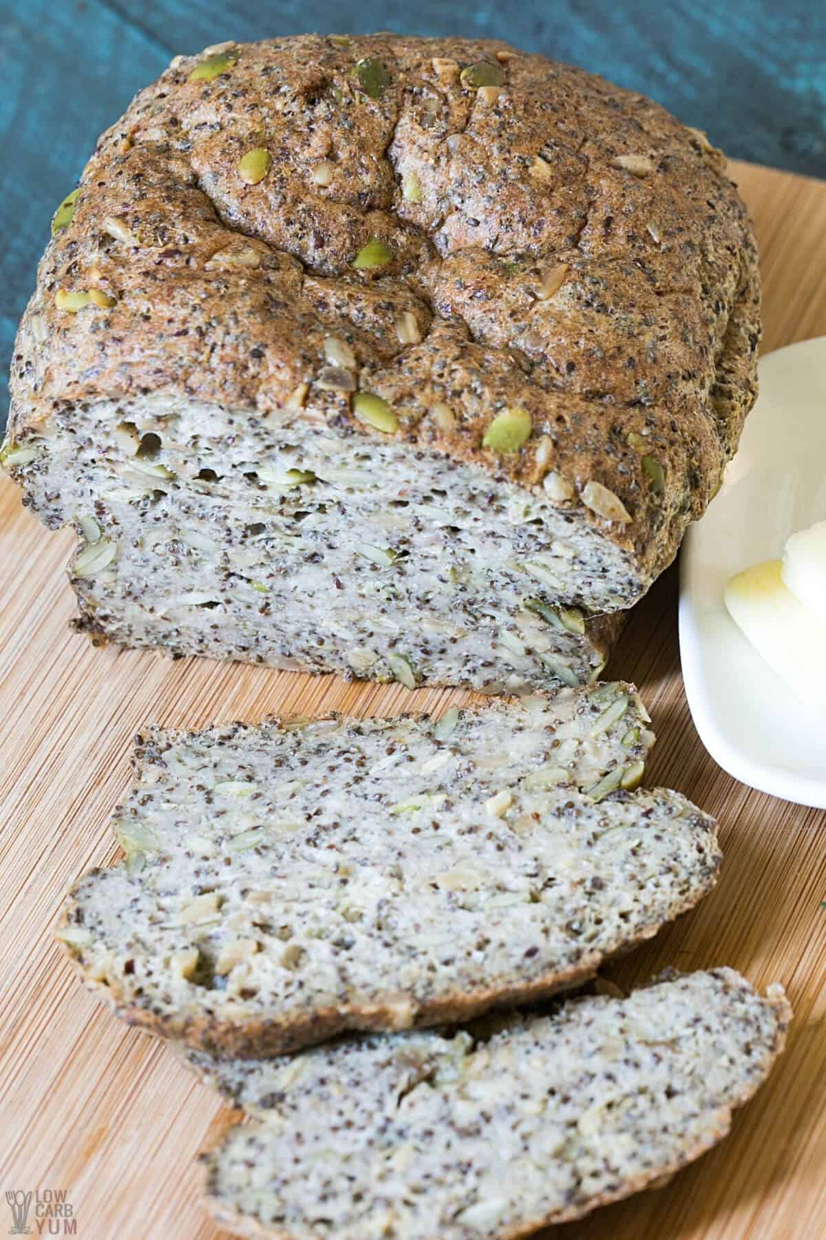 pumpkin seed bread sliced on wood cutting board