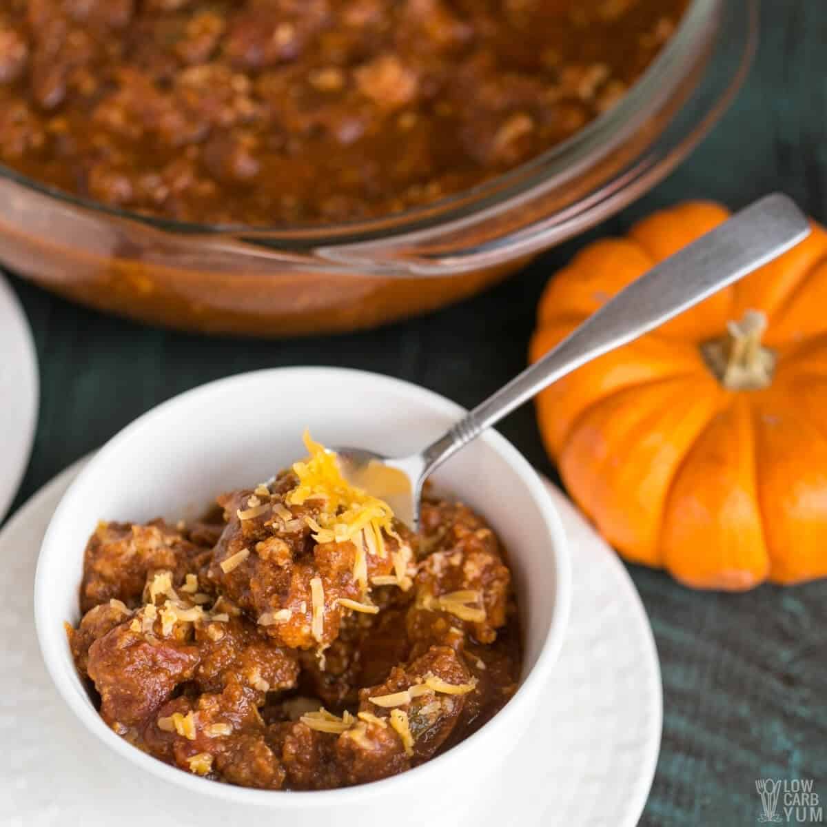 turkey pumpkin chili in white bowl with cheese