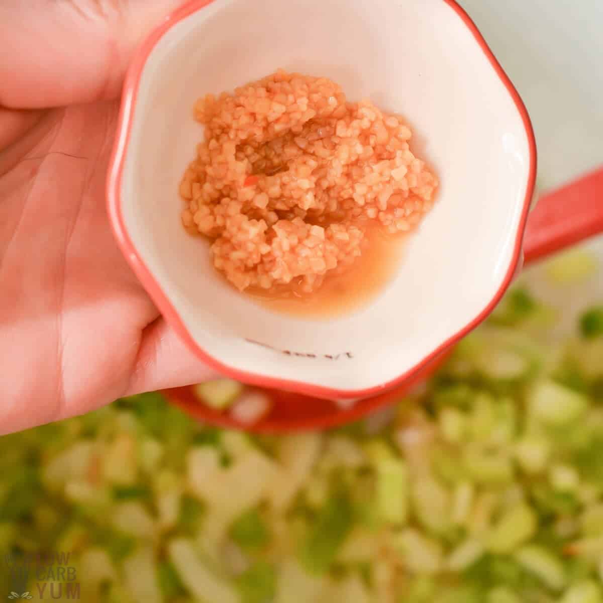 adding minced garlic