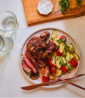 steak with sautéed zucchini and tomato