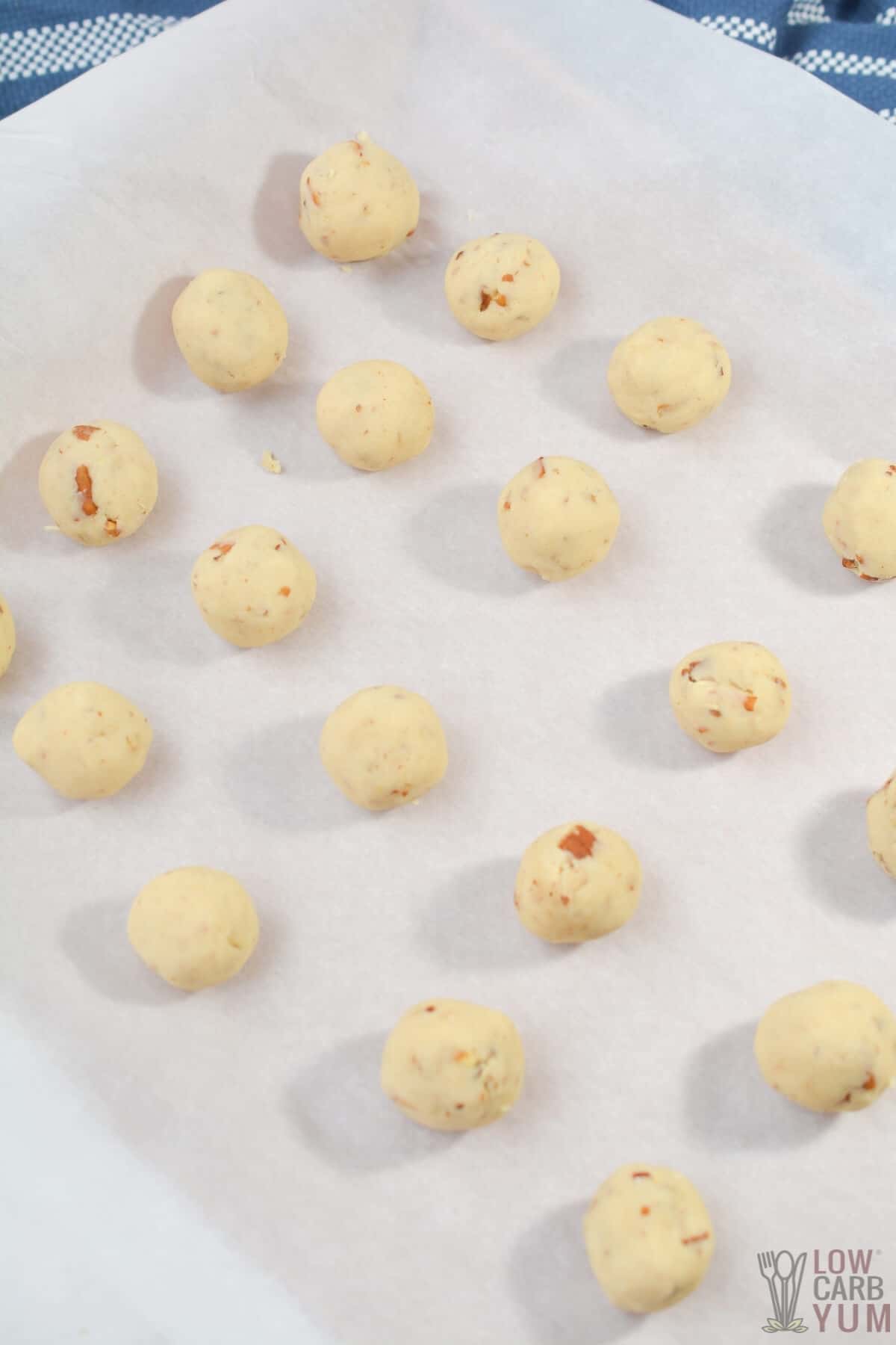 cookie dough balls on parchment paper lined baking sheet