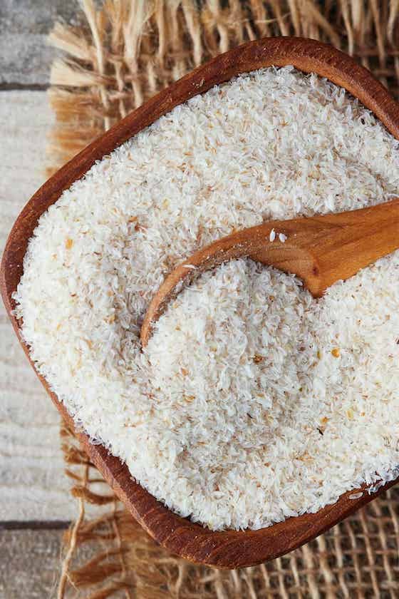 psyllium husks in wooden bowl with spoon overhead shot