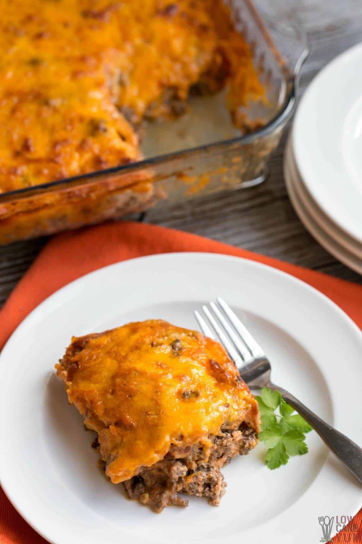 serving a slice of cheeseburger casserole on white plate