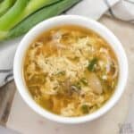 overhead shot of egg drop soup in white bowl