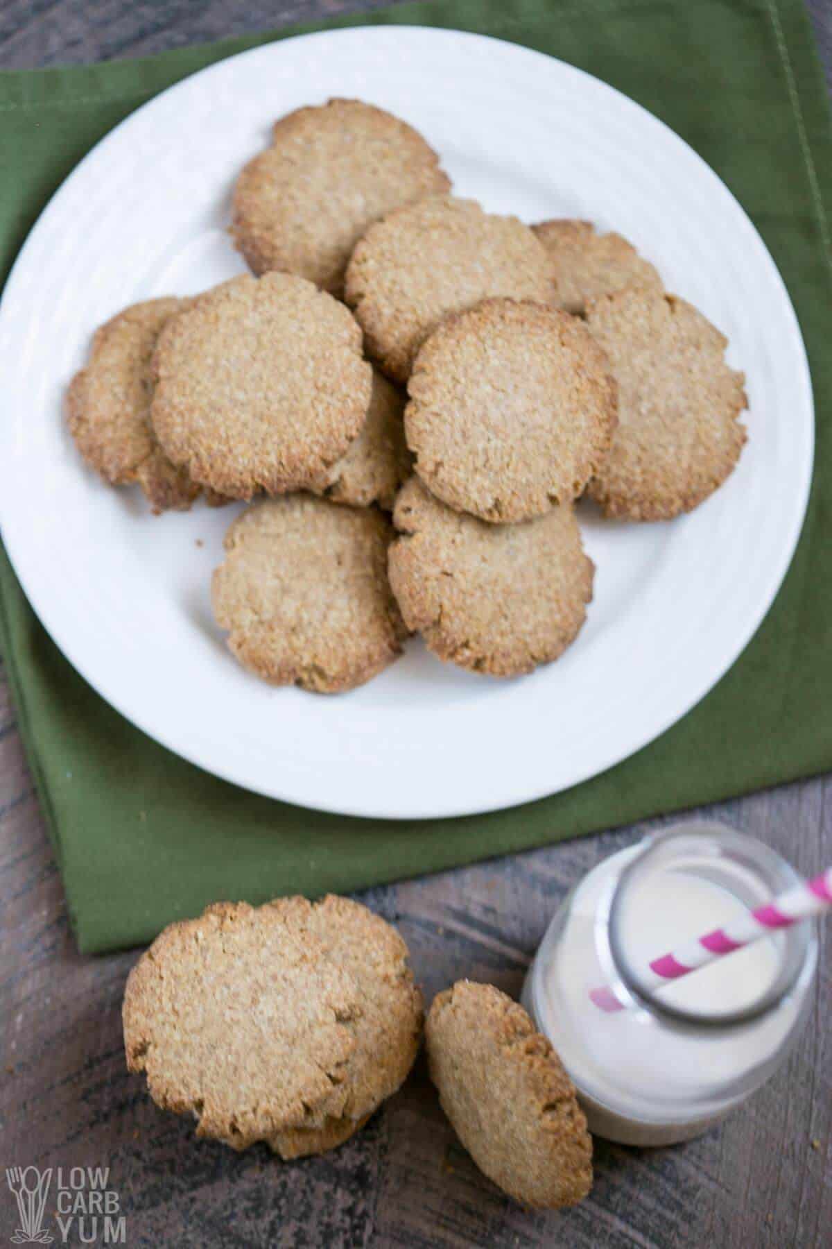 keto ginger snaps on white plate and stacked next to glass bottle of milk