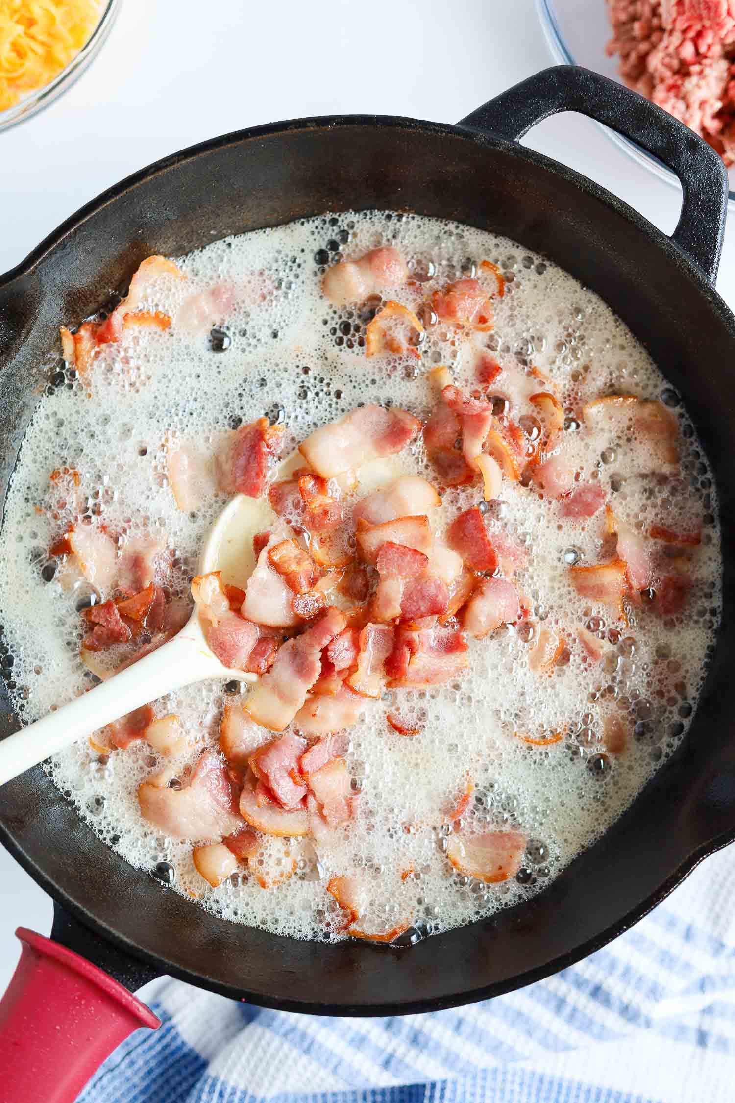 cooking bacon on a cast iron skillet with bacon grease