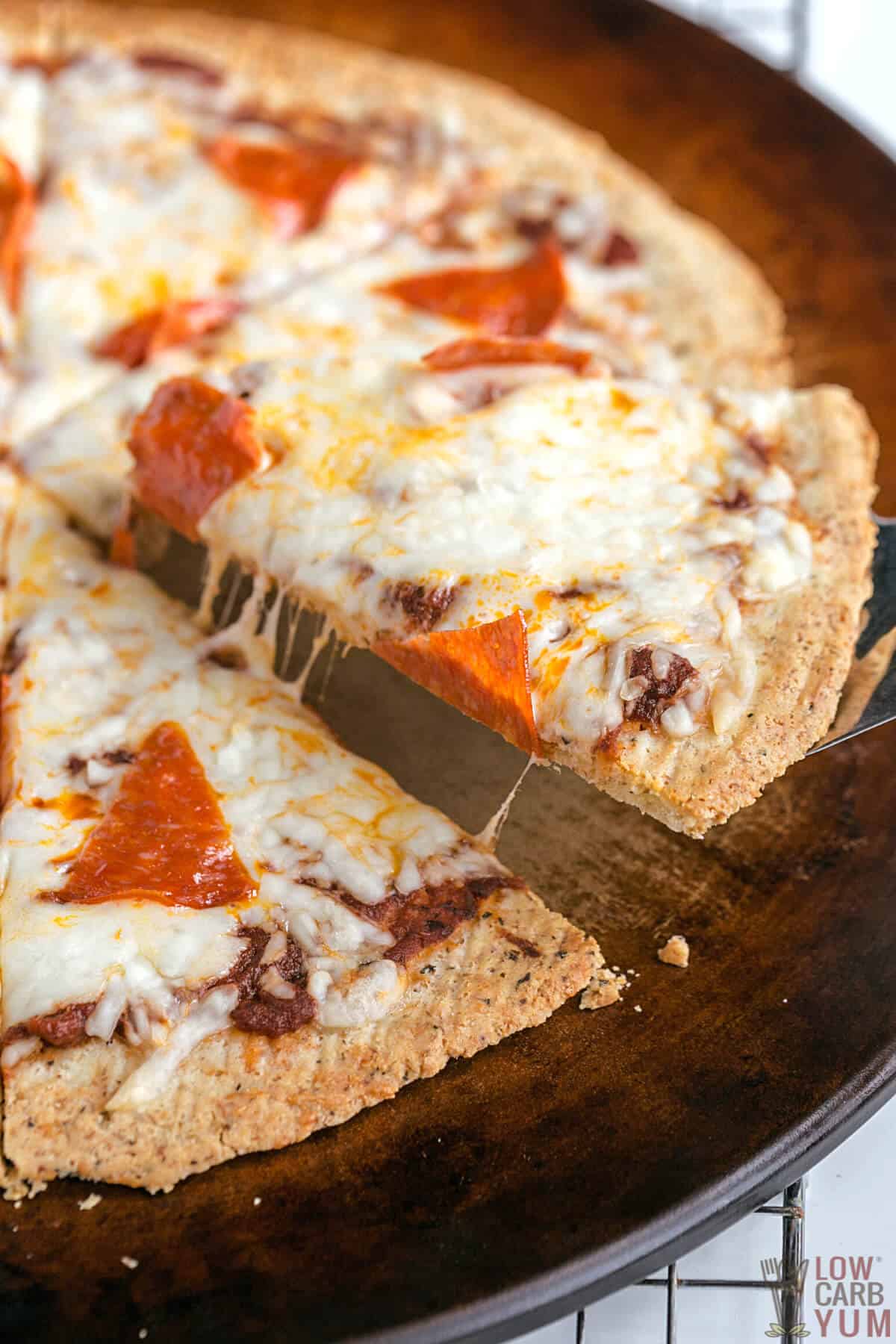 cutting pizza made with almond flour crust