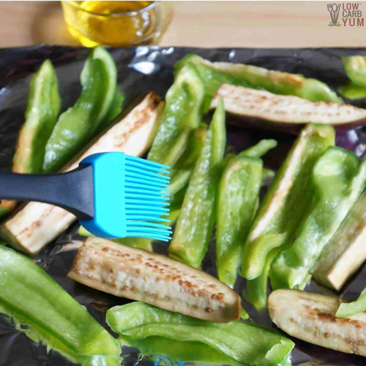 brushing olive oil on cut eggplant and bell peppers