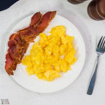 scrambled eggs on white plate with bacon