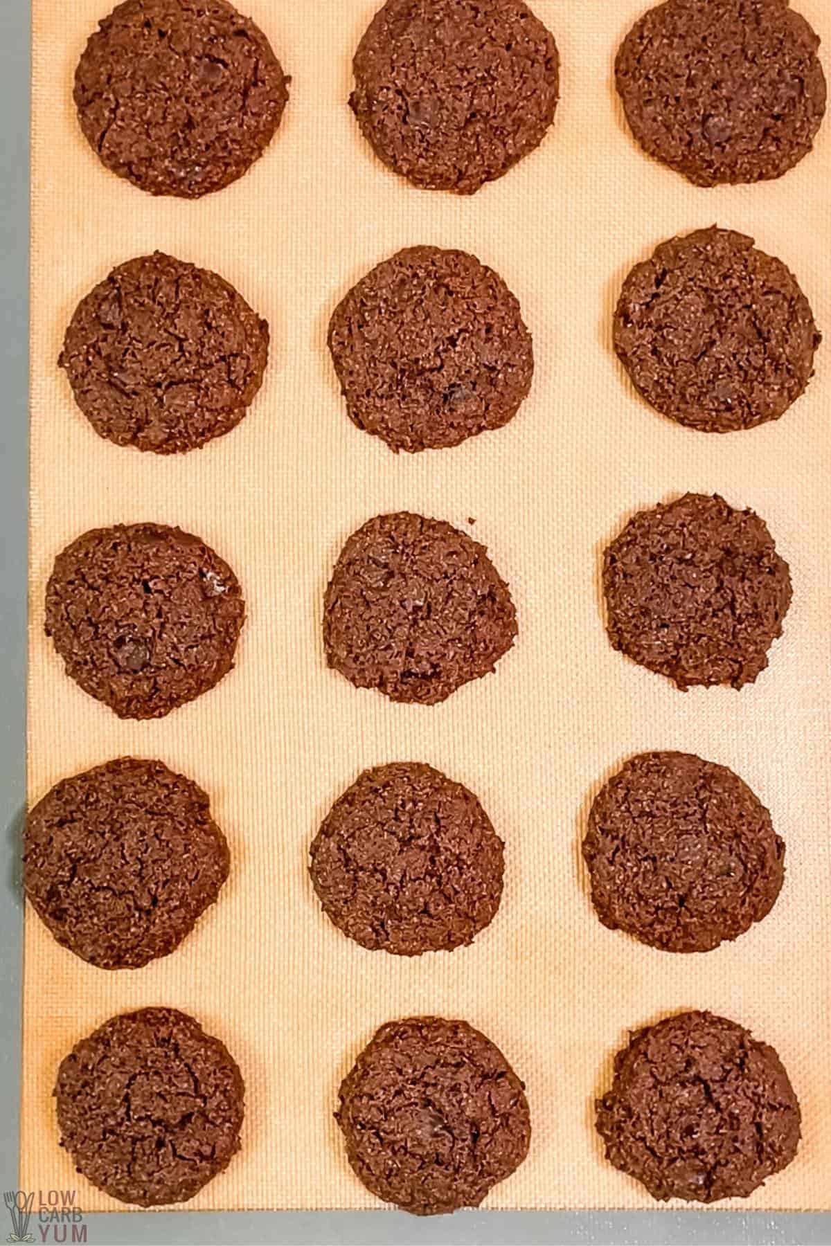 baked chocolate cookies on silicone mat lined baking sheet.