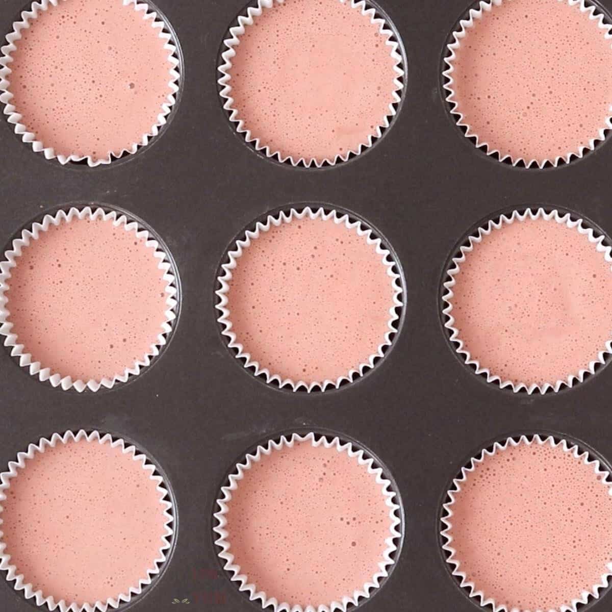 cupcake batter divided in paper liners inside muffin pan