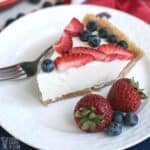 keto no bake cheesecake slice with berries on white plate