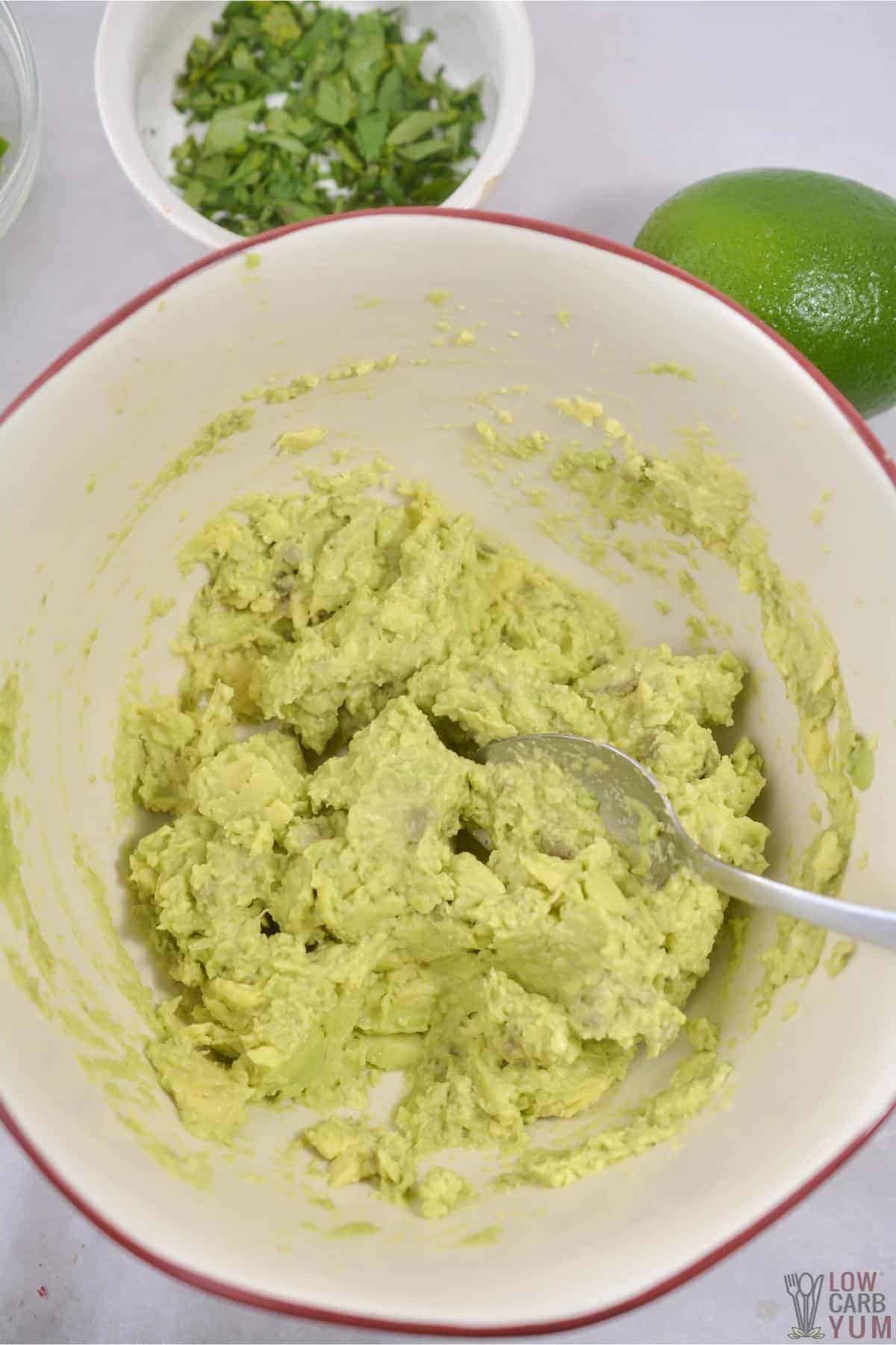 mashed avocado in white bowl.