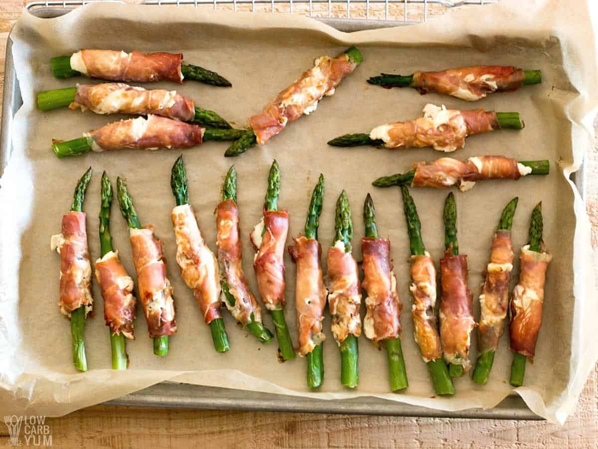 cooked wrapped asparagus on lined baking sheet.