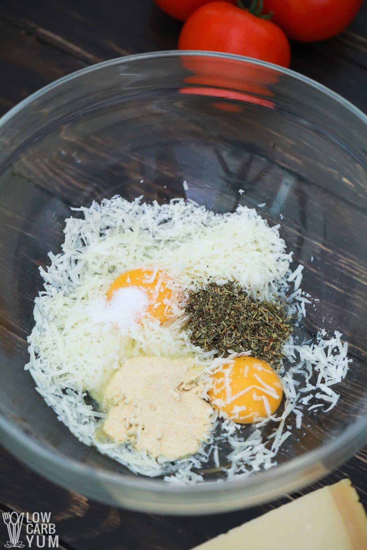 eggs parmesan cheese and spices in mixing bowl.