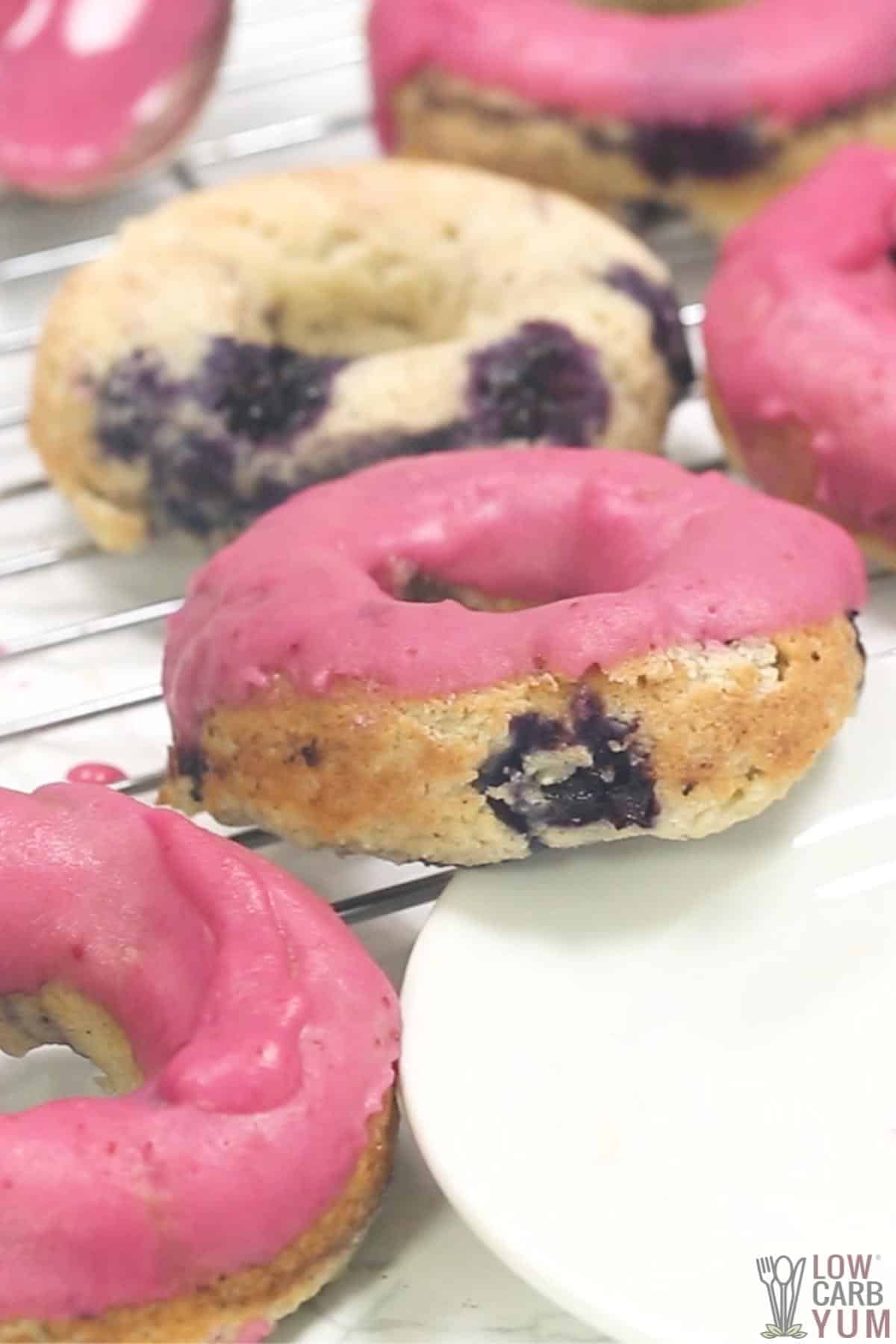 pink iced keto blueberry donuts on rack