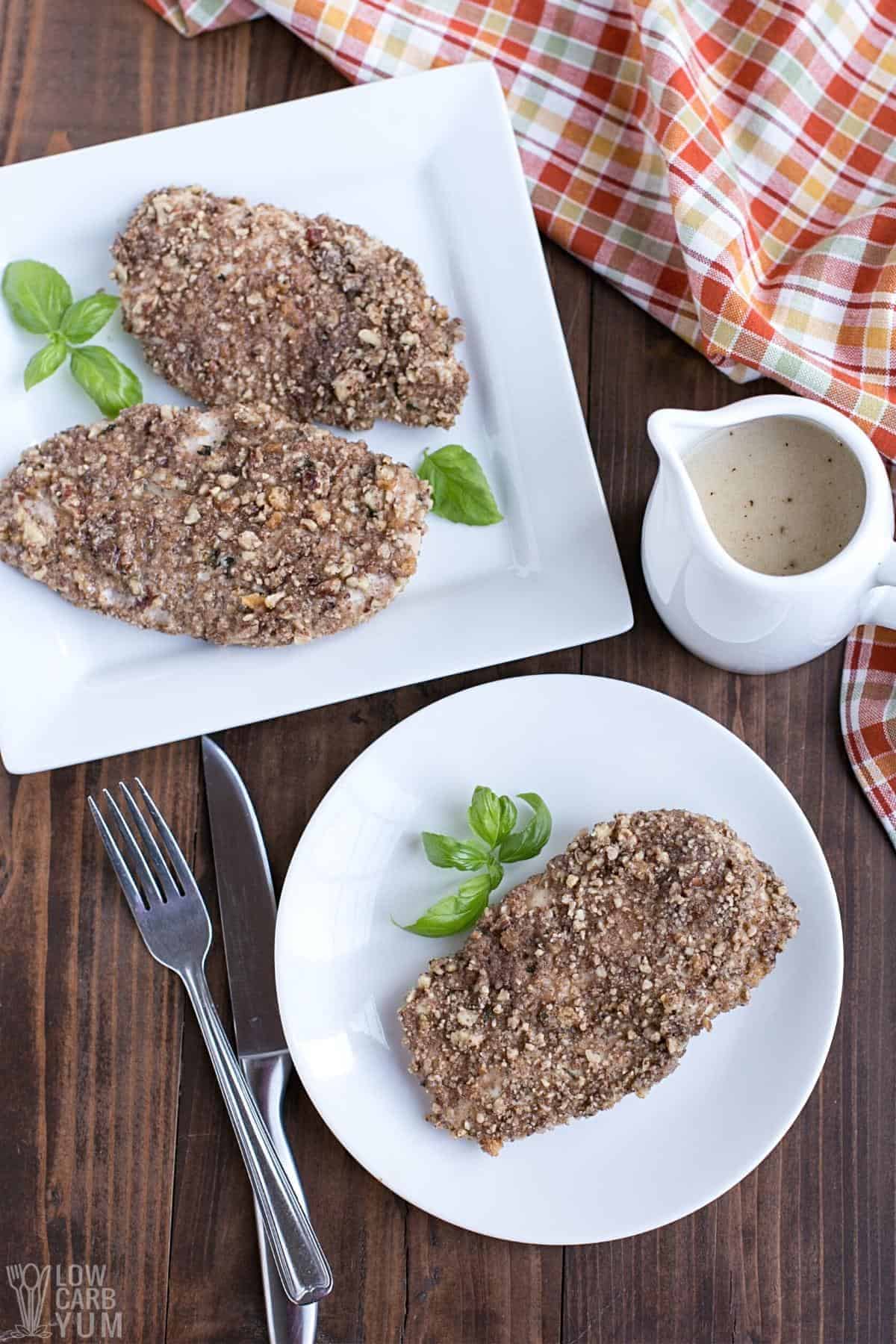 pecan crusted chicken on white plates.