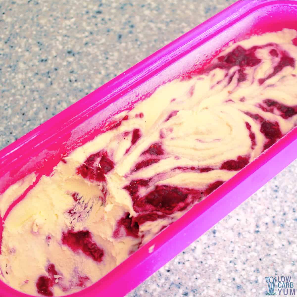 raspberry swirl ice cream in freezer tub.