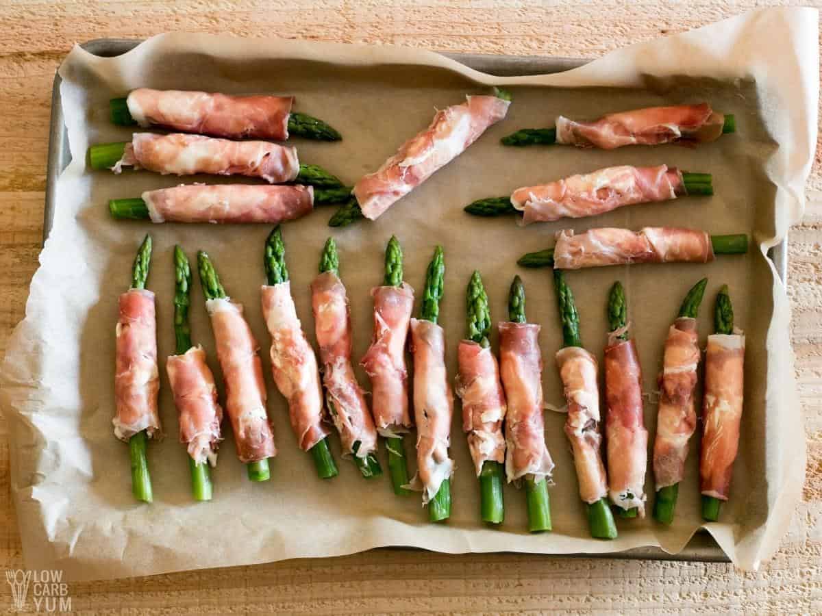 uncooked asparagus wrapped with cream cheese and prosciutto.