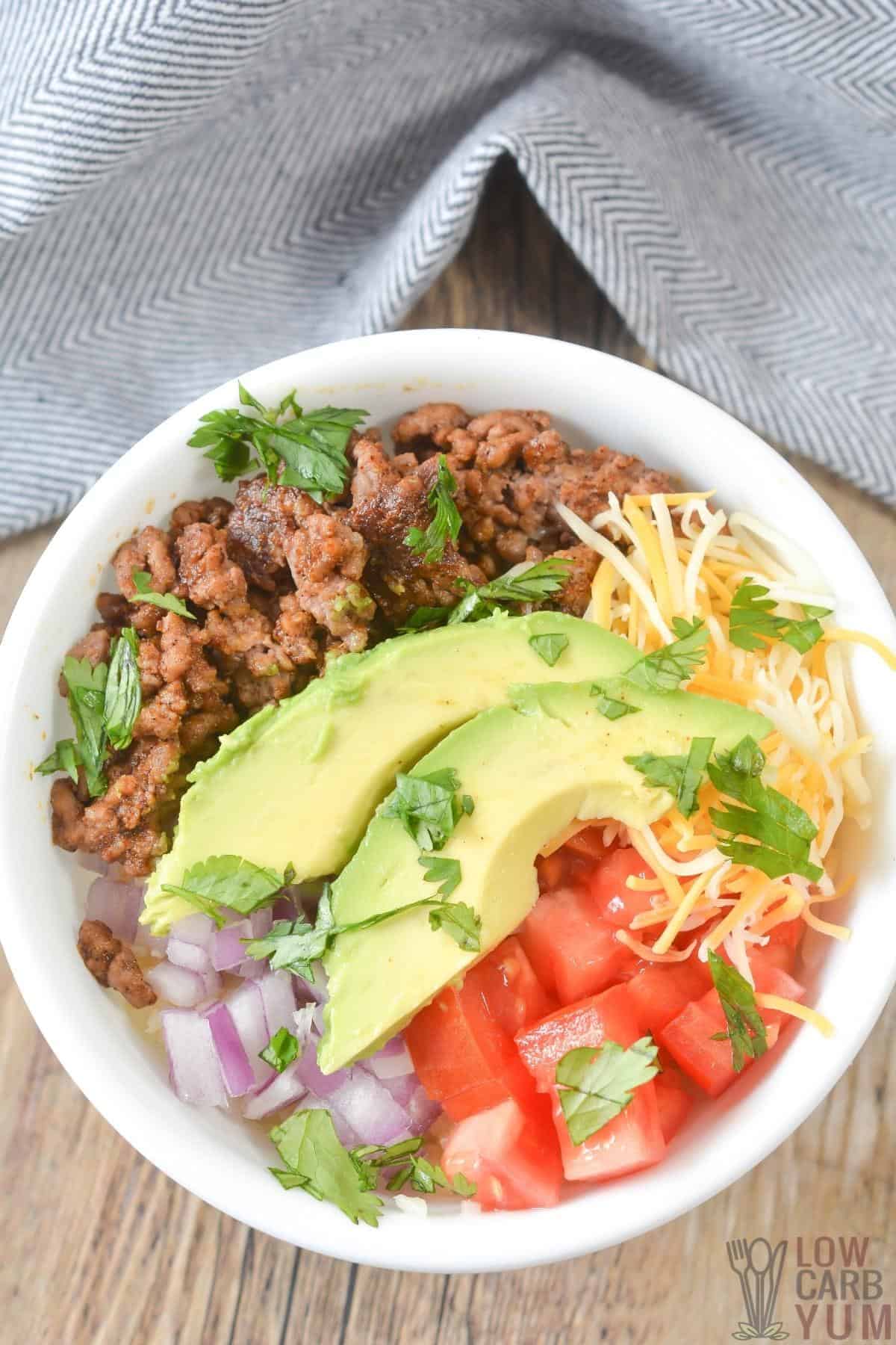 ground beef topped with cheese, avocado, onion, tomato and cilantro