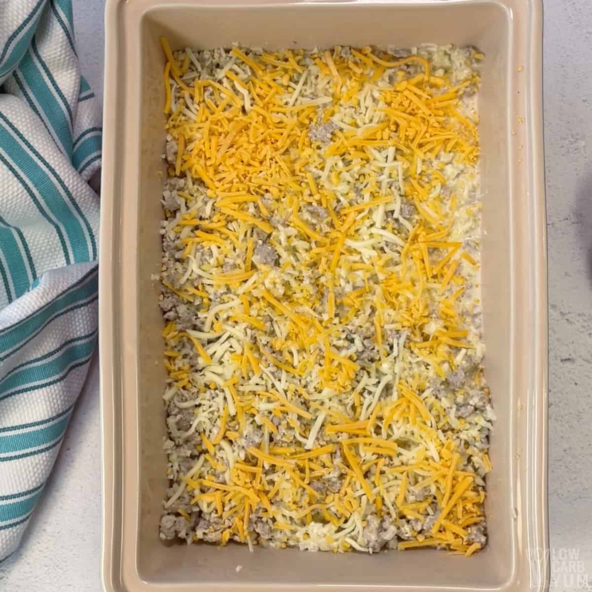 unbaked casserole topped with cheese