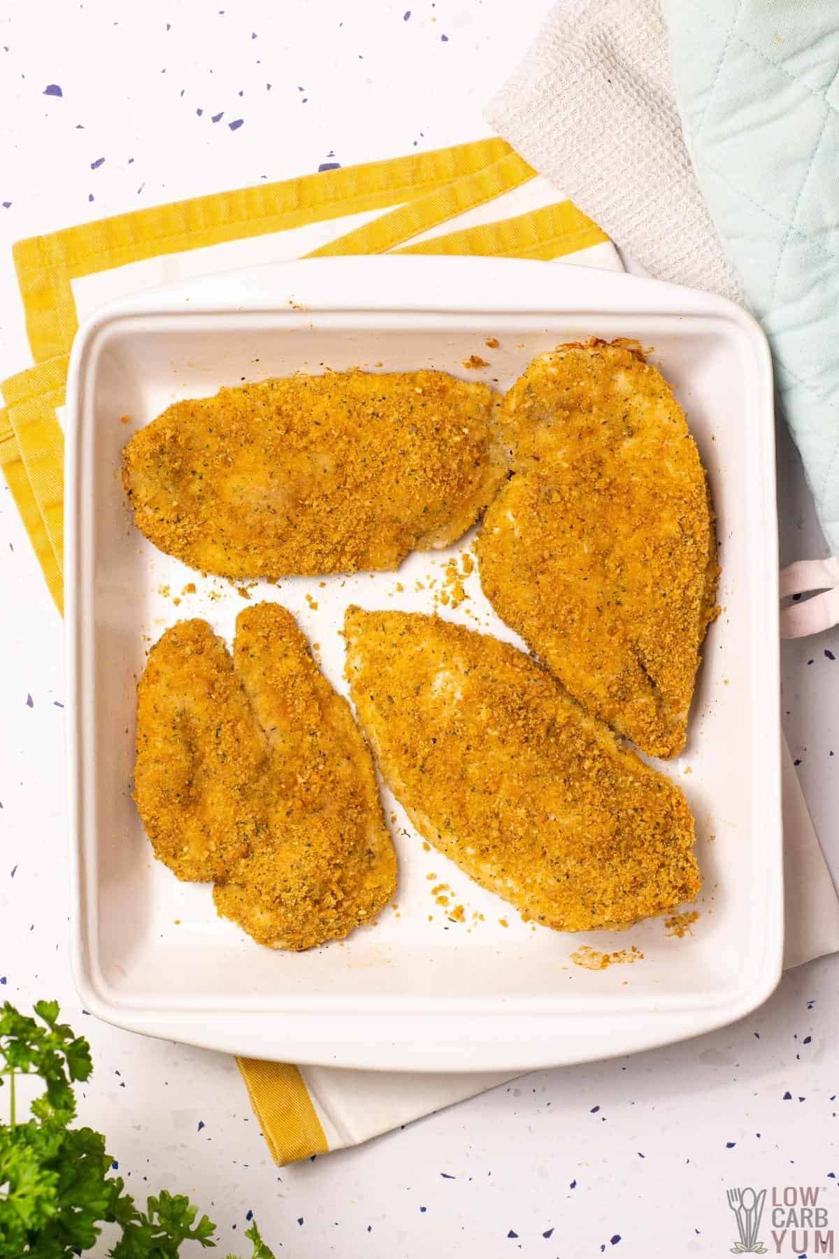 coated chicken in baking pan.