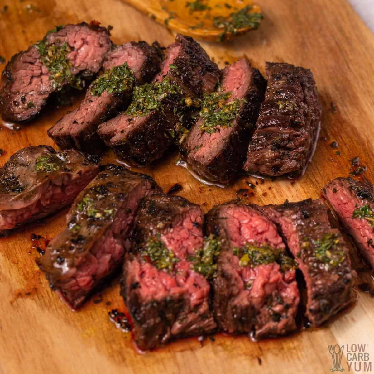 chimichurri flank steak sliced on cutting board.
