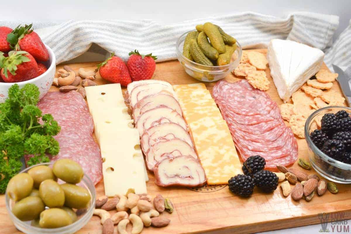 meat cheese board with nuts and fruit.