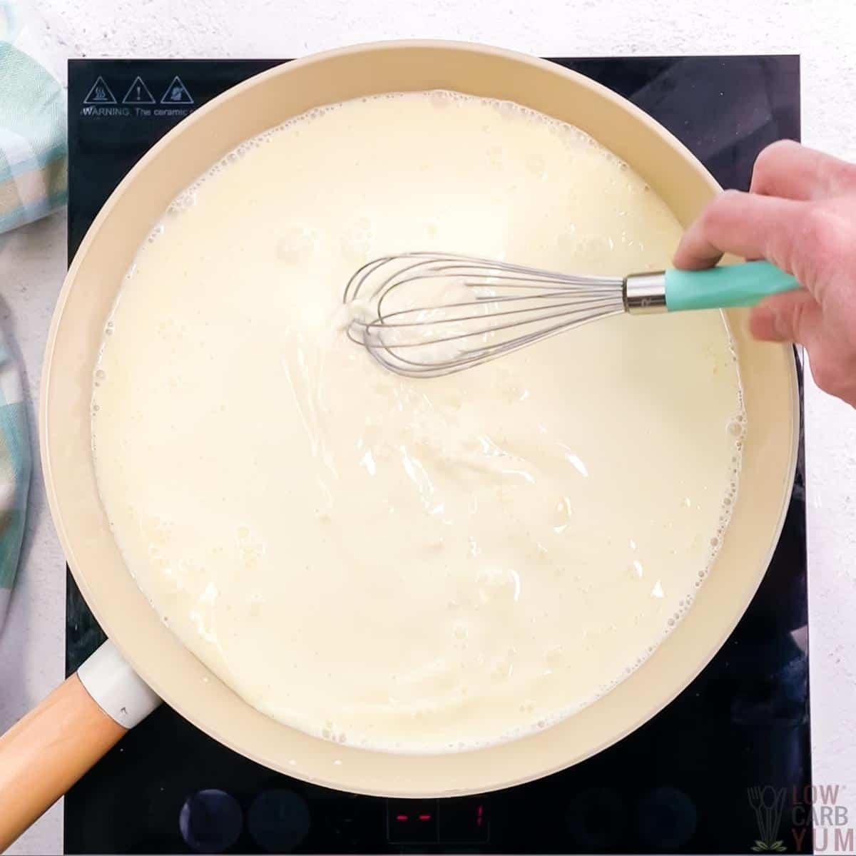 whisking ingredients together in pan on cooktop.