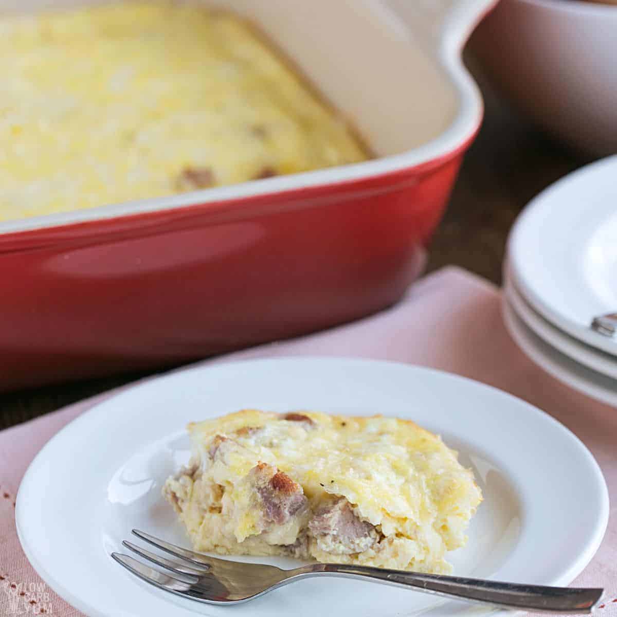 serving of egg bake with ham and cheese on white plate.