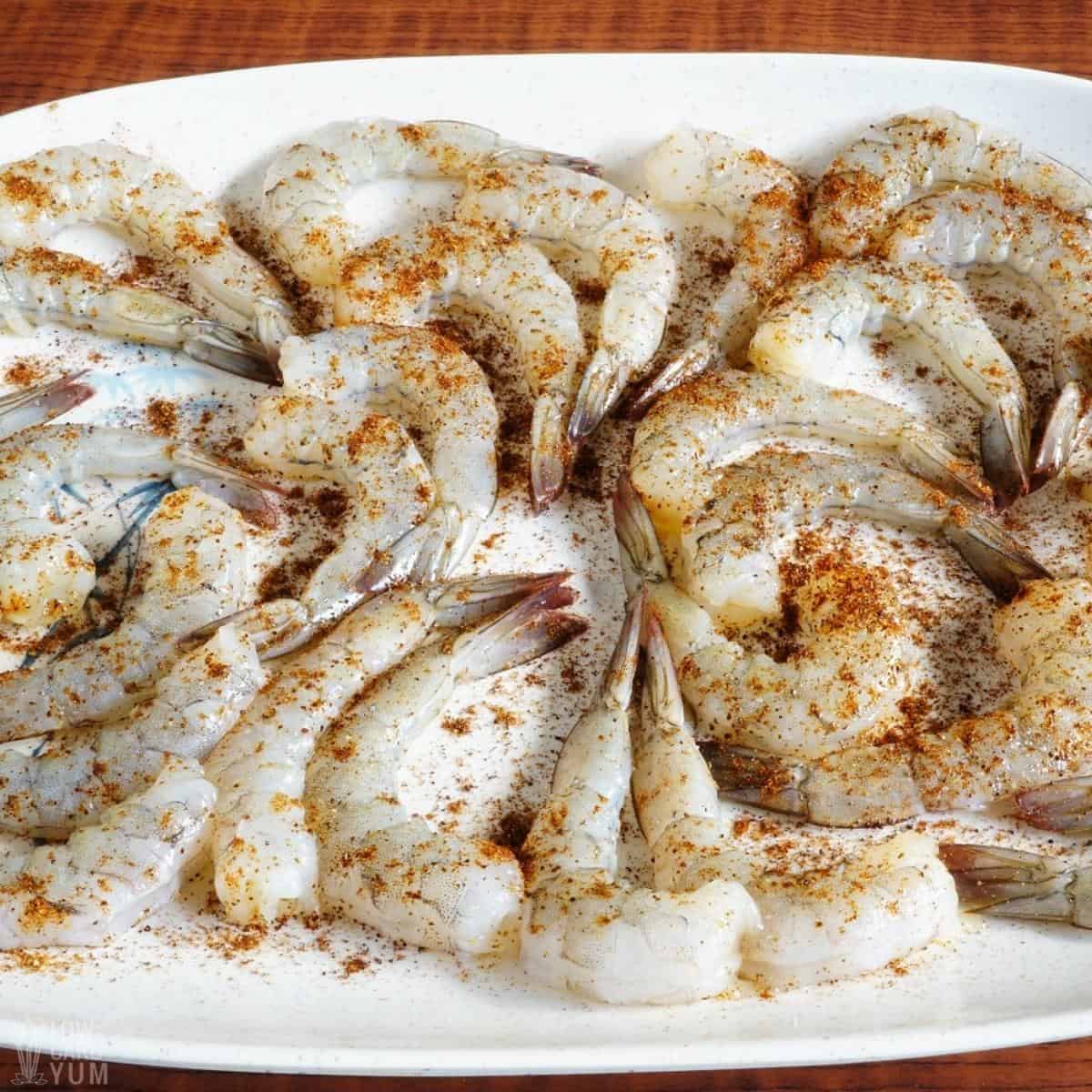 seasoned shrimp for fajitas on white platter.