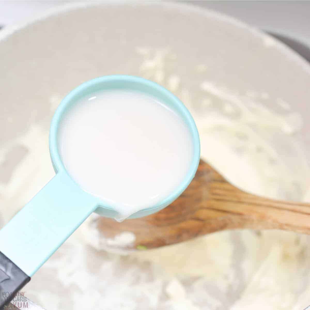 adding almond milk to the melted cream cheese.