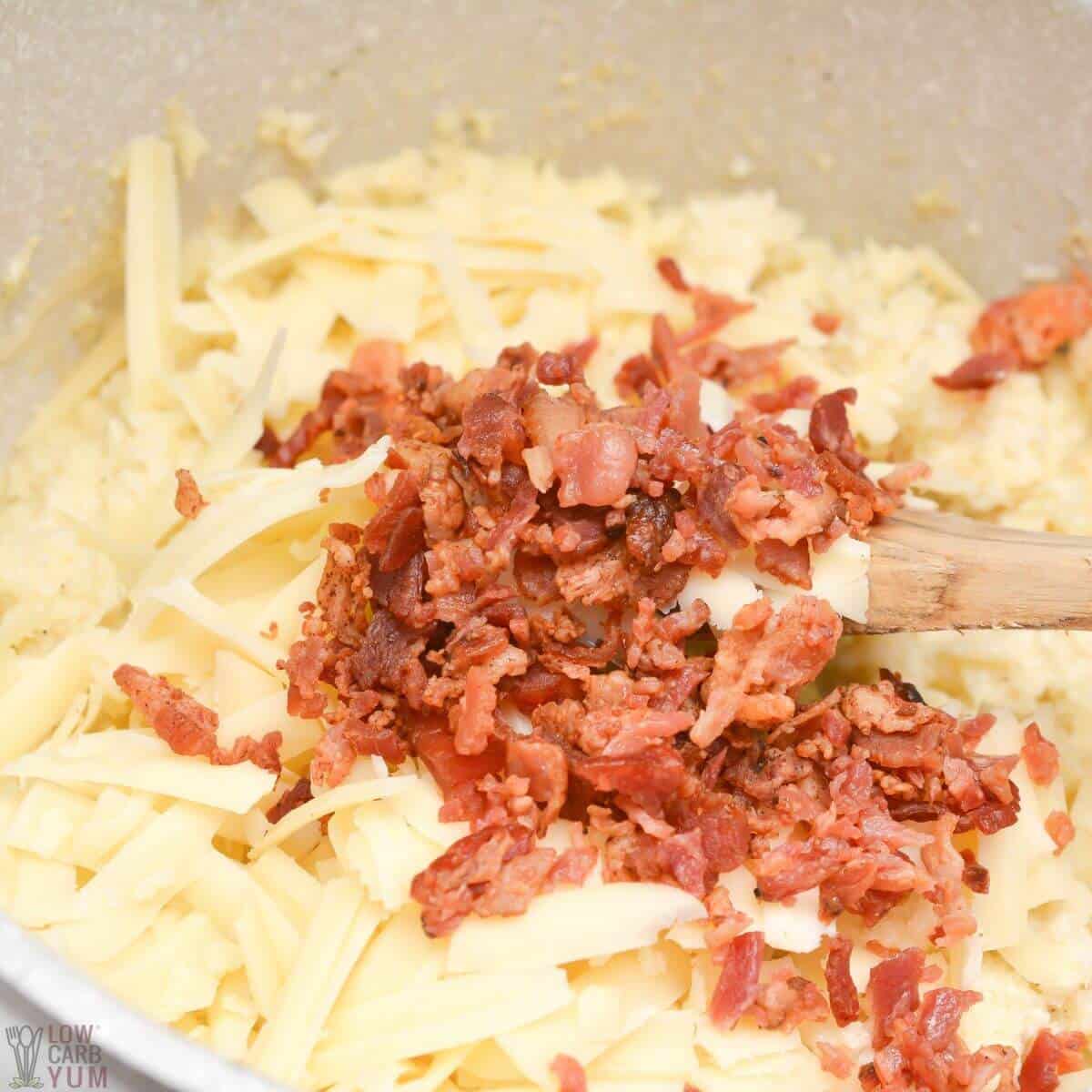 adding cheese and bacon to cauliflower.